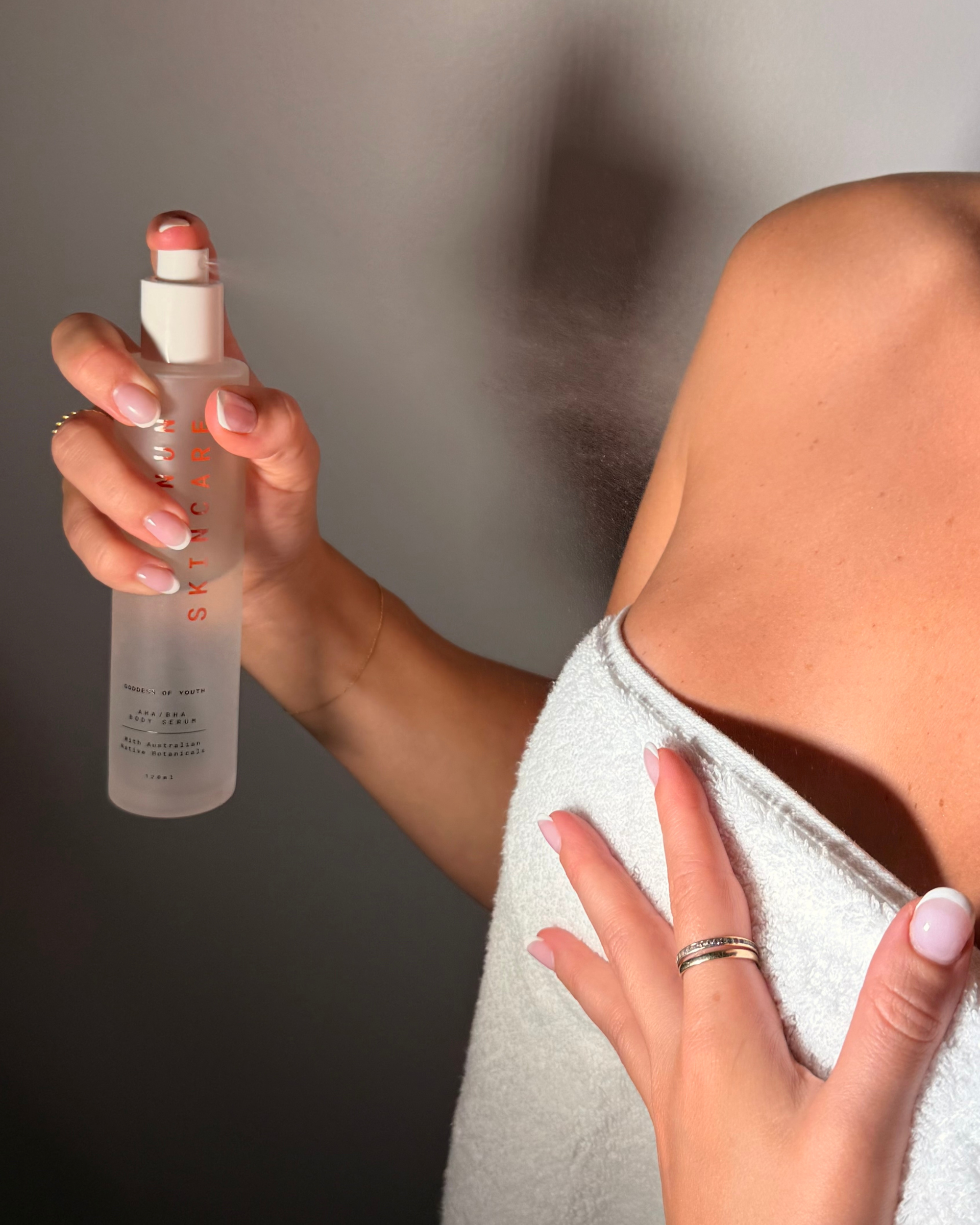 Goddess of Youth body serum held beside body skin
